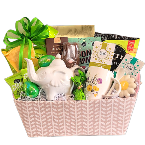 A basket with an elephant teapot and floral mug, along with chocolates, an assortment of biscuits and more.
