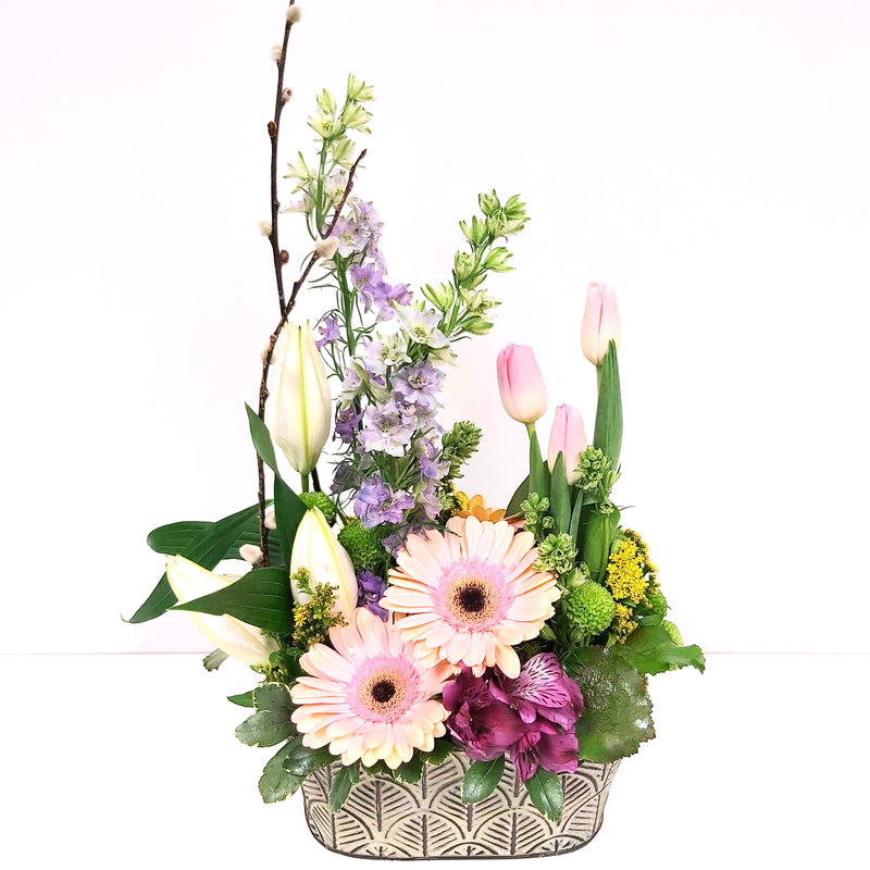 Floral arrangement in a pretty tin filled with gerberas, tulips, lilies and more.
