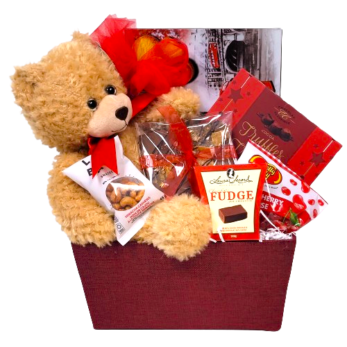 A gift basket with a teddy bear, classic truffles, chocolate bark, nuts, jelly beans and biscuits too.