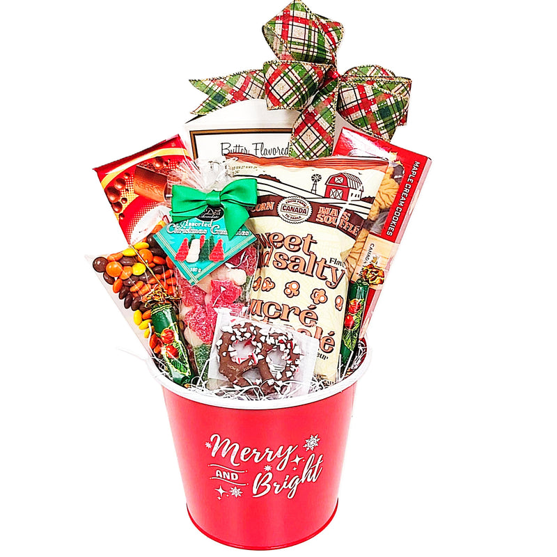 Christmas gift basket in red and scribed with Merry and Bright. Loaded with pretzels, chocolate, cookies, popcorn and candy treats galore! Lots of holiday treats to indulge in.