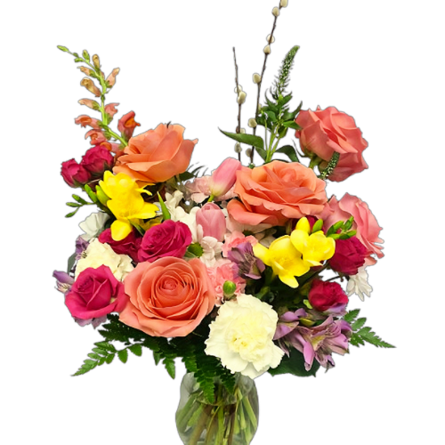 A lush assortment of spring blooms in hues of yellow, pinks, purple and white. Tulips, roses, and more are beautifully designed in a glass vase.