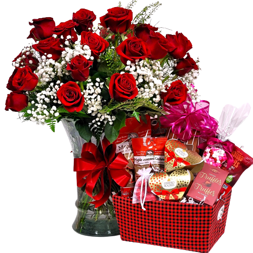 An arrangement of two dozen red roses with a gift basket of sweet treats.
