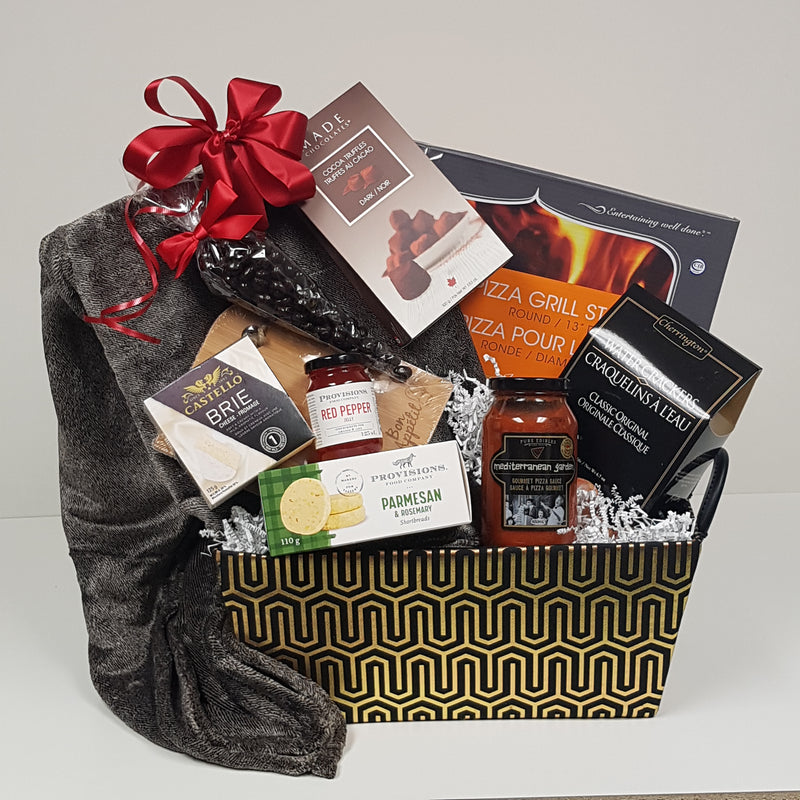 A decorative box filled with a pizza grill stone, pizza sauce, crackers and cheese, savoury shortbread, a fireside blanket , red pepper jelly, truffles and more.