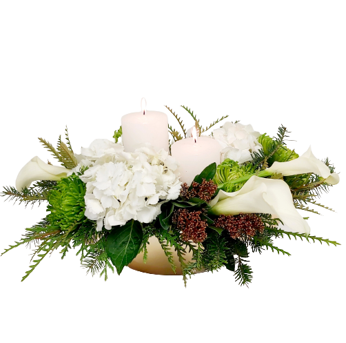 Two pillar candles amongst Christmas greens and blooms.