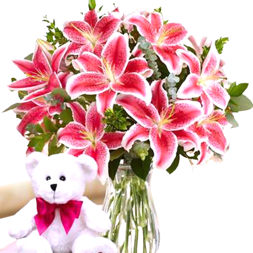 Beautiful vase arrangement of lilies with and teddy bear