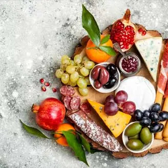 A gourmet cheese, meat, and fruit board.
