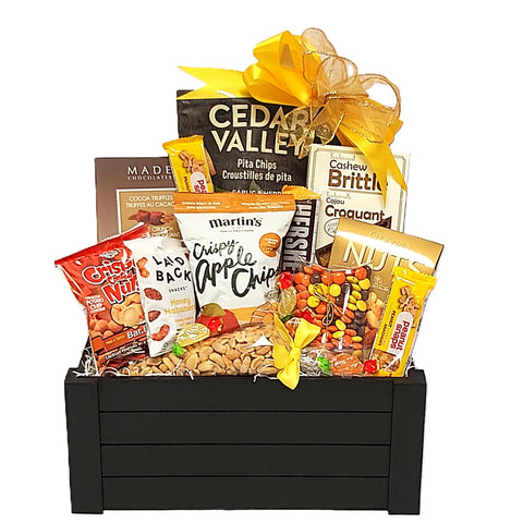 A wooden crate filled with delectable sweet and nutty treats. There's an assortment of chocolate and truffles, nuts and chips too!