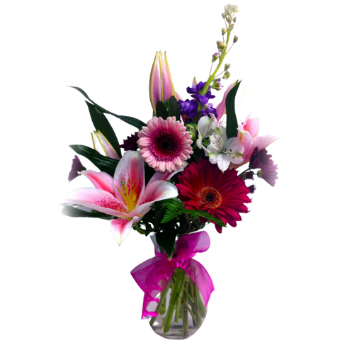 Vase floral arrangement with lilies, gerbera and more in pinks, reds, purples and white.