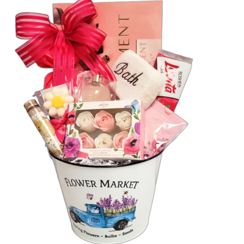 A gift basket filled with chocolate, cookies, bath salts, soap petals, bubble bath and a scented sachet.