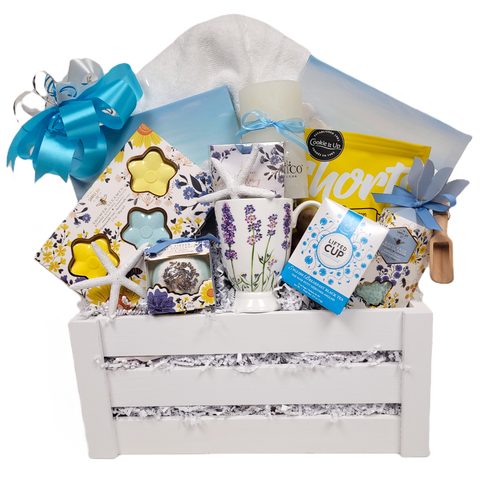 Shower steamers, a bath fizzer, bath salts, a fragrance sachet, a pillar candle, a mug, tasty shortbread, a plush bath towel, two mini ocean prints, and pretty seashells too!