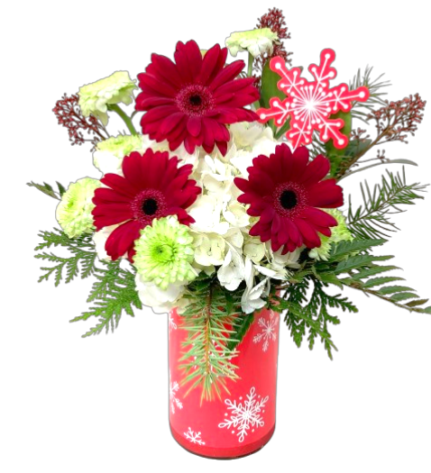 A floral arrangement of gerbera, hydrangea and poms in a snowflake vase.