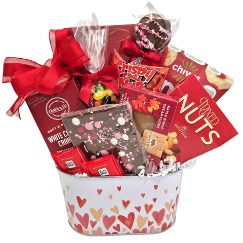 Gift basket with chocolates, an assortment of nuts, cookies, fudge, apple chips, truffles, jelly beans and more in a heart decorated gift tin.