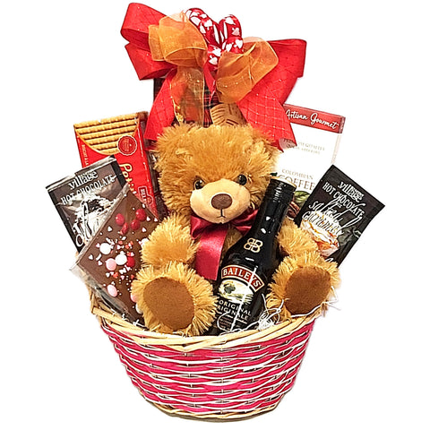 Gift basket with teddy bear, chocolate, coffee, hot chocolate and a bottle of Baileys liqueur nestled in a wicker gift basket.