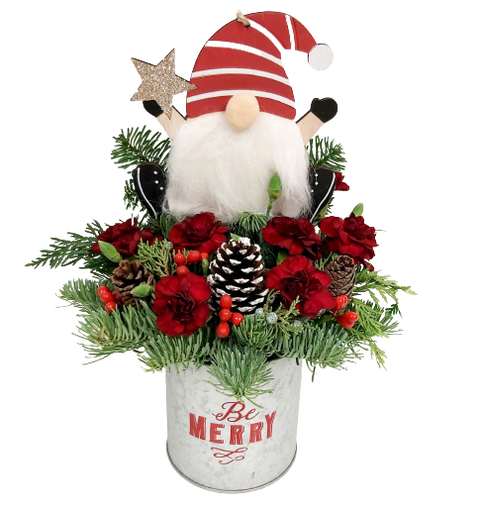 A little gnome nestled amongst long-lasting Christmas greens and florals in a rustic 'Be Merry' tin.