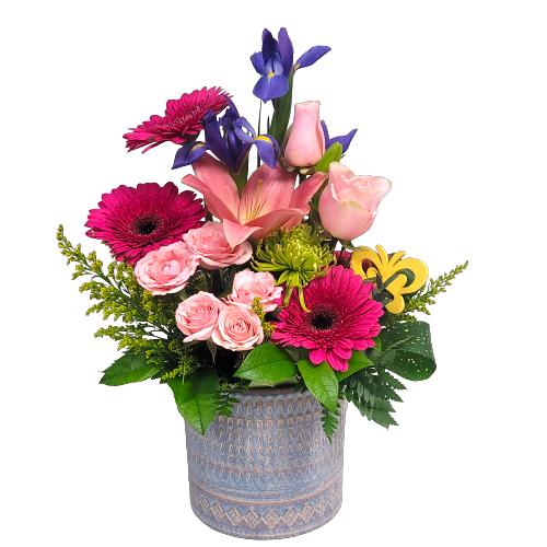 A pretty ceramic pot filled with enchanting blooms in hues of pink, a bit of purple and green too! 