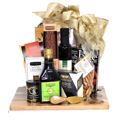 A cheese board and knife set with artisanal salami, oil, vinegar, cheese, mustard, salmon, chocolate and more.