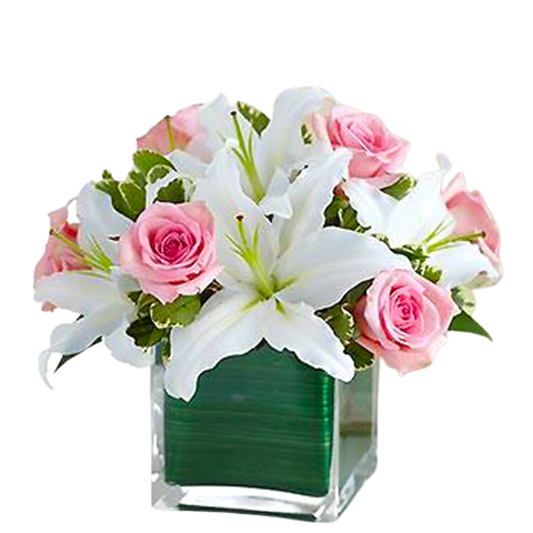 Lovely floral arrangement in clear cube vase with pink roses and white lilies.
