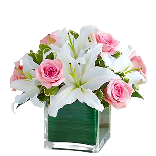 Lovely floral arrangement in clear cube vase with pink roses and white lilies.