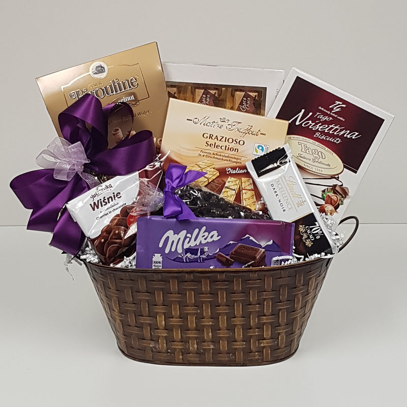 A basketful of chocolate delights including a fine selection of chocolate cookies, chocolate wafers, chocolate coffee beans, milk chocolate, dark chocolate, chocolate, chocolate and more chocolate.