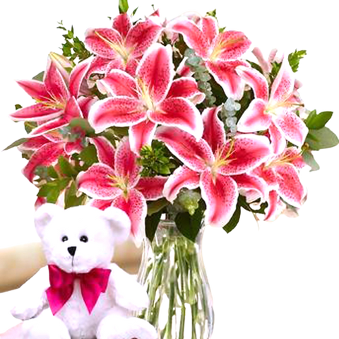 Beautiful vase arrangement of lilies with and teddy bear